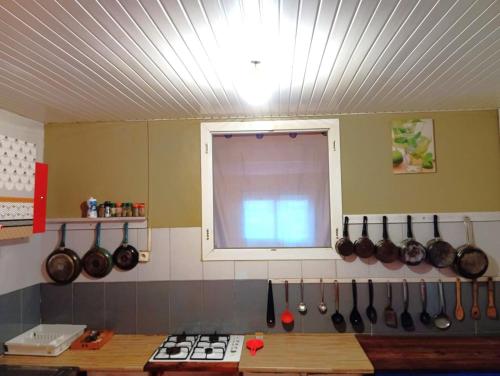 een keuken met een raam en enkele potten en pannen bij Hostel des 3 sources in Sainte-Marie