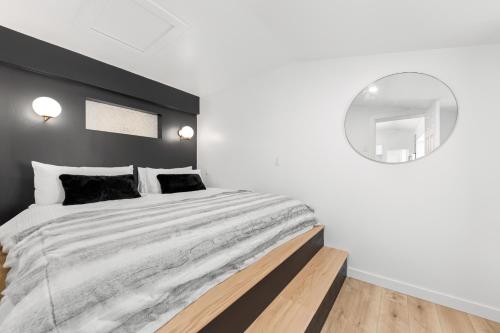 a bedroom with a large bed and a round mirror at Les Petits Chalets in Val-des-Lacs