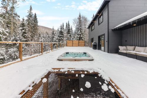 a backyard with a hot tub in the snow at Les Petits Chalets in Val-des-Lacs