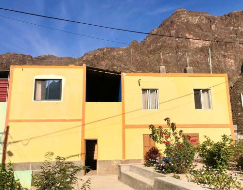 um edifício amarelo com uma montanha ao fundo em Casa Manuel & Elvira 