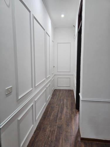 an empty hallway with white walls and wood floors at Milano Hotel in Hải Dương