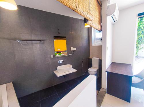 a bathroom with a sink and a toilet at The Yacht Riverside Villa Near Colombo International Airport in Ganepola