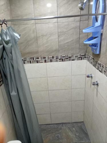 a shower with a shower curtain in a bathroom at Hostal Atlantis in Quito