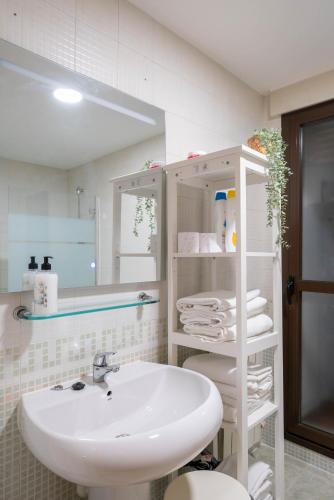 a white bathroom with a sink and a mirror at Apartamento GO- La Ermita -Parking Gratuito in Arroyo de la Encomienda