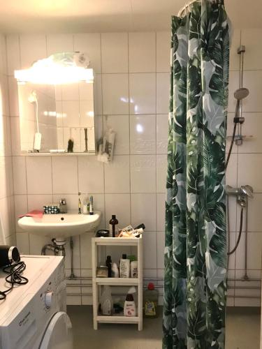a bathroom with a sink and a shower curtain at Cosy room in Pasila in Helsinki