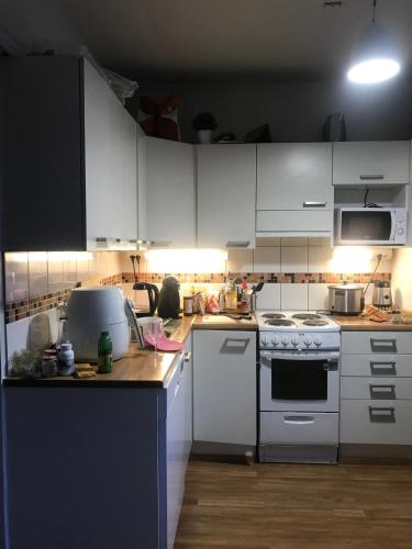 a kitchen with white cabinets and a stove top oven at Cosy room in Pasila in Helsinki