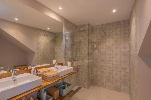 a bathroom with two sinks and a shower at Private 250sqm Garden Duplex, Jacuzzi, Cinema, Sea View Escape in Torremolinos