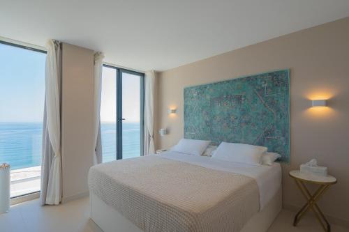 a bedroom with a large bed with a large window at Seaside Tranquility and Urban Luxury - Stylish Duplex in Torremolinos w jacuzzi in Torremolinos