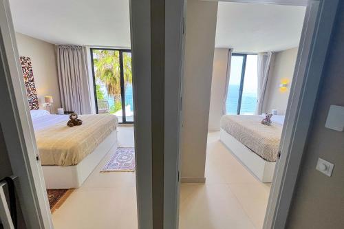 a bedroom with two beds and a view of the ocean at Private 250sqm Garden Duplex, Jacuzzi, Cinema, Sea View Escape in Torremolinos