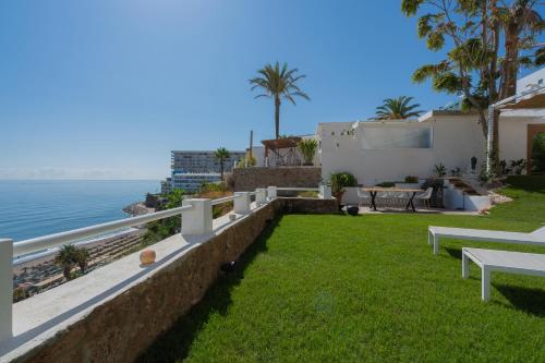 a backyard with a view of the ocean at Private 250sqm Garden Duplex, Jacuzzi, Cinema, Sea View Escape in Torremolinos