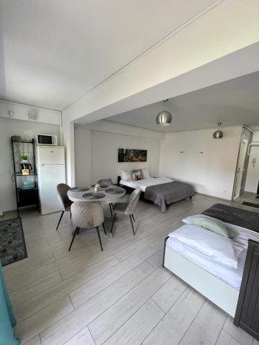 a bedroom with a bed and a table and chairs at Welcome to Bucharest Airport Residences & Therme-SELF CHECK-IN in Otopeni