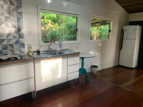 a kitchen with a sink and a refrigerator at Pousada Jardim Da Lagoa in Florianópolis