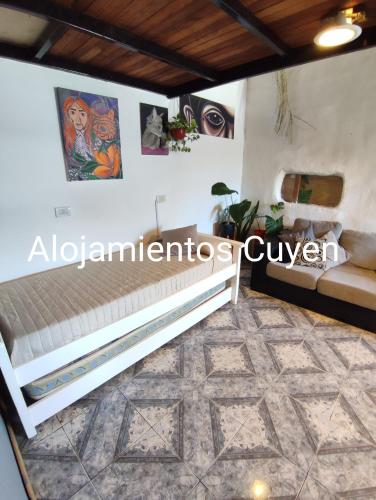 Habitación con cama y pinturas en la pared. en Alojamientos CUYEN para 4 personas Playa Quequen y El Faro en Quequén