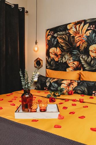 a bed with a table with flowers on it at Villa La'Vie in Witbank