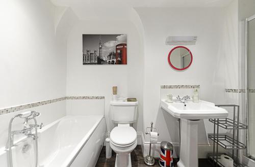 a white bathroom with a toilet and a sink at Mama’s Inn Boutique Guest House in Nottingham