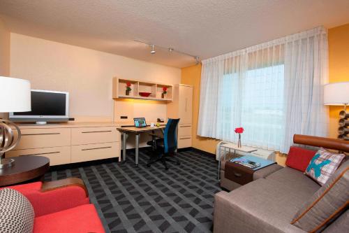 a living room with a couch and a desk with a computer at TownePlace Suites Des Moines Urbandale in Johnston