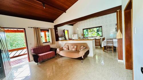 ein Wohnzimmer mit einem Sofa und einem Stuhl in der Unterkunft Residência Aconchego in Ilhabela