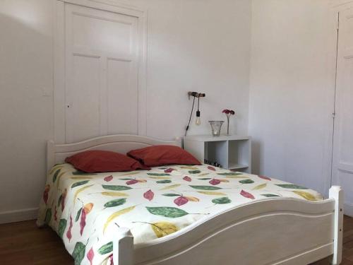 a bedroom with a bed with a floral comforter at Villa et visite du vignoble organisée et Piscine in Nuits-Saint-Georges