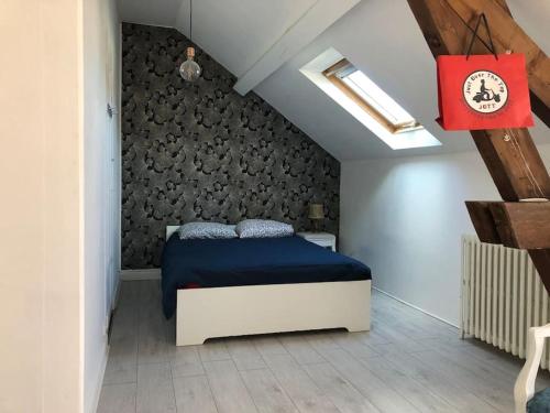 um quarto com uma cama azul num sótão em Villa et visite du vignoble organisée avec Spa et Piscine em Nuits-Saint-Georges