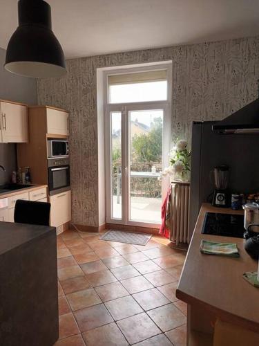 a kitchen with a door leading to a patio at Villa et visite du vignoble organisée et Piscine in Nuits-Saint-Georges
