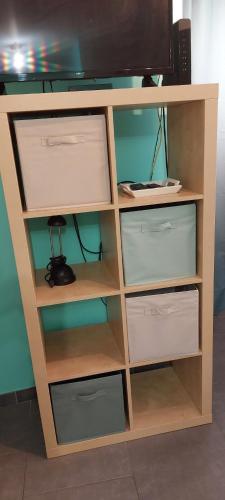 une étagère en bois avec des tiroirs et une télévision dans l'établissement Charmant studio, à Avignon