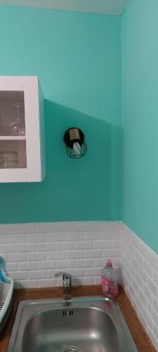 - une cuisine avec un évier et un mur bleu dans l'établissement Charmant studio, à Avignon