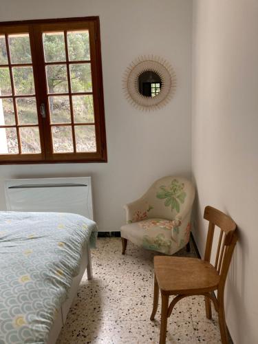 um quarto com uma cama, uma cadeira e um espelho em Le refuge em La Verdière