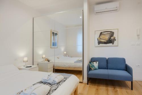 een slaapkamer met een bed en een blauwe stoel bij Alexander's Nest in Trieste