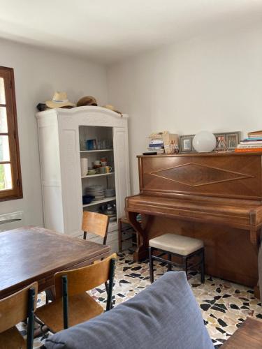 uma sala de estar com um piano e uma mesa em Le refuge em La Verdière