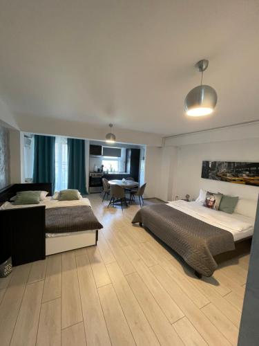 une chambre d'hôtel avec deux lits et une salle à manger dans l'établissement Welcome to Bucharest Airport Residences & Therme-SELF CHECK-IN, à Otopeni