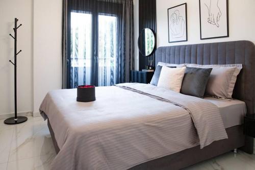 um quarto com uma cama grande e uma cabeceira cinzenta em PARIS Opulent Lifestyle em Drama