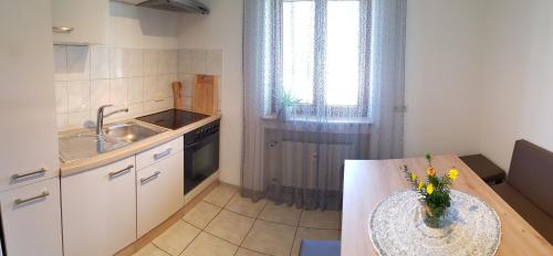 a kitchen with a table with a vase of flowers on it at Apartment Morgensonne in Oberau