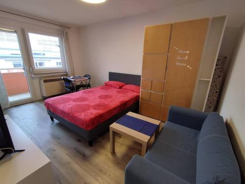 1 dormitorio con cama roja y sofá en Studio Apartment in City Center, en Sindelfingen