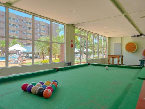 a pool table with balls in a room with windows at Apto para 6 pessoas no melhor resort dos Lençóis in Barreirinhas