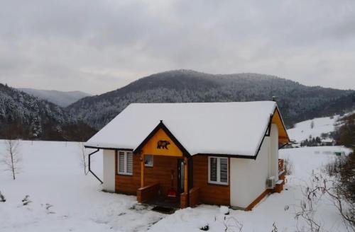 Cabaña pequeña con nieve en el techo en Chatka Niedźwiadka en Uście Gorlickie