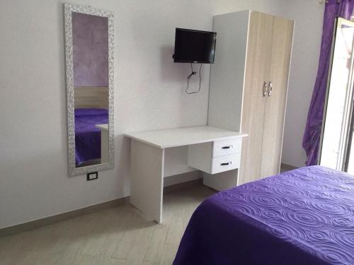 a bedroom with a white desk and a mirror at Red Stone in Diamante