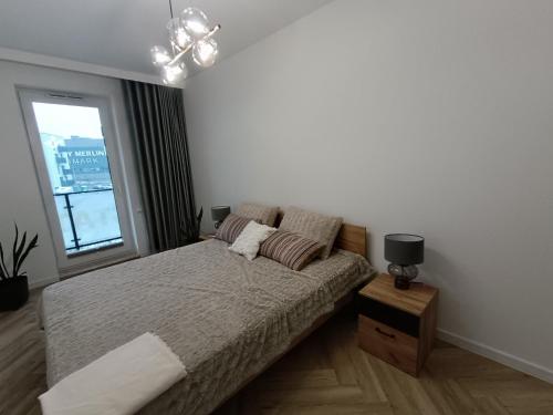 Un dormitorio con una cama grande y una ventana en Amaprament Do Poznania self check-in 24h, free parking, en Poznan