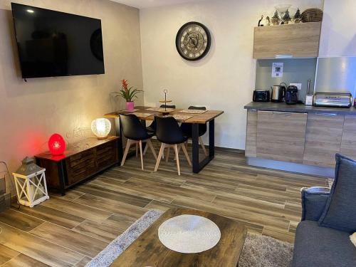 a living room with a table and chairs and a kitchen at Maison 4 personnes centre-lac in Gérardmer