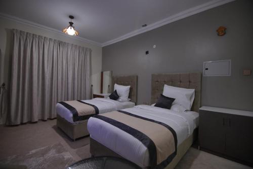 a hotel room with two beds and a tub at Sea Shore Hotel Apartment Khorfakkan in Khor Fakkan