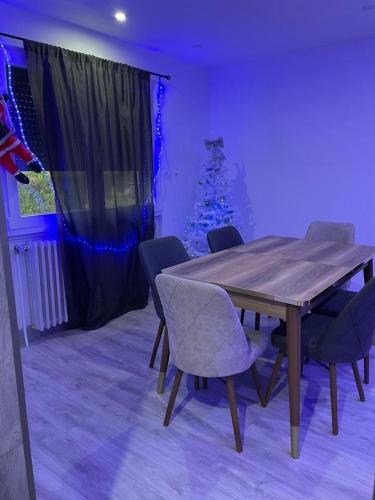 a dining room with a wooden table and a christmas tree at la Colombière in Longvic