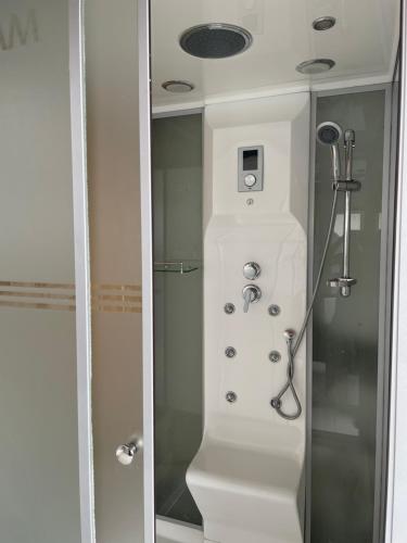 uma casa de banho com chuveiro e cabeça de chuveiro em Kantree House - Safari Suites em Kampala