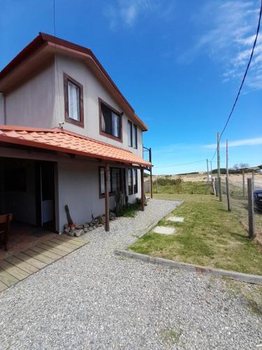 a white house with a red roof and a yard at Aroma de mar casas en alquiler vacacional con hermosa piscina in Sauce de Portezuelo