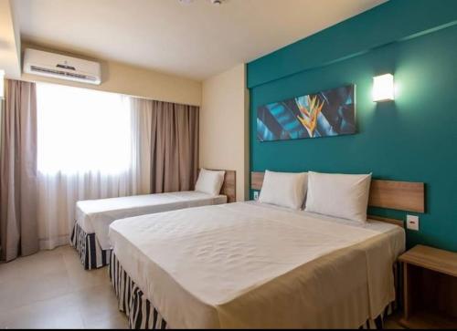 ein Hotelzimmer mit zwei Betten und einer blauen Wand in der Unterkunft Olímpia Park Resort in Olímpia