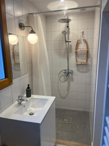 uma casa de banho branca com um chuveiro e um lavatório. em L ermitage Appartement 4 couchages avec terrasse et jardin, à 7 kms de Metz em Lessy
