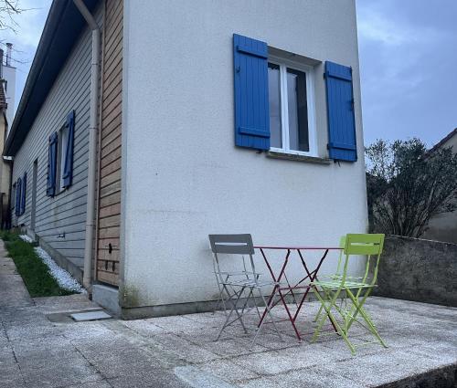 two chairs and a table in front of a building at L ermitage Appartement 4 couchages avec terrasse et jardin, à 7 kms de Metz in Lessy