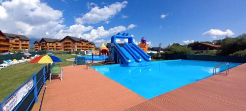 une grande piscine avec un toboggan bleu dans l'établissement Tatragolf - Apartmán Milan K 204, à Veľká Lomnica