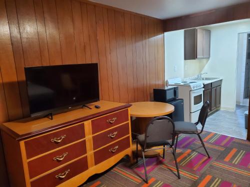 a kitchen with a table and a tv on a dresser at Thunder Bird Motel in Mountain Home