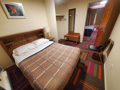 a hotel room with a bed and a hallway at Thunder Bird Motel in Mountain Home