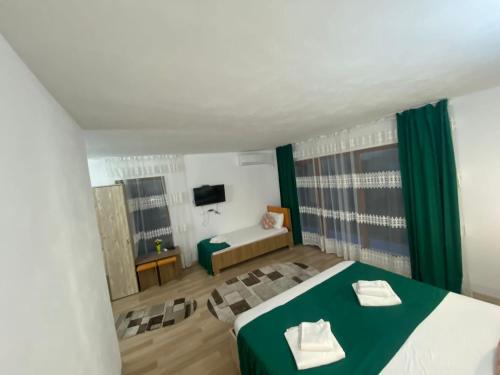 a bedroom with a green and white bed and a television at Paradiso Resort in Sarinasuf
