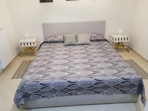 a bedroom with a large bed with two night stands at Casa Sambuco in Volla